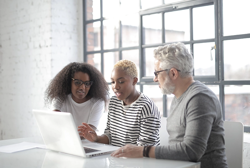 3 people looking at laptop